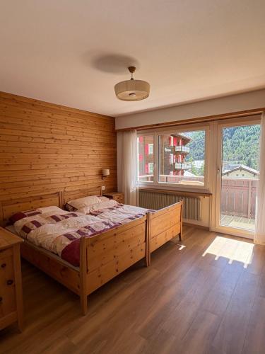 a bedroom with a bed and a large window at Salü 5 in Saas-Fee