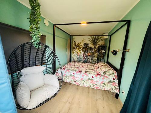 a room with a swinging bed and a chair at Le repaire du raton laveur in Rance