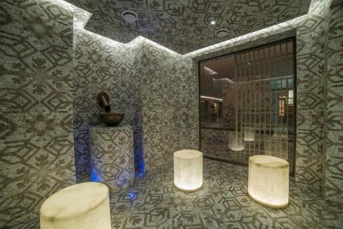 a bathroom with two stools and a mirror at Cunda Callisto Hotel & Spa Adult Only 12 in Ayvalık