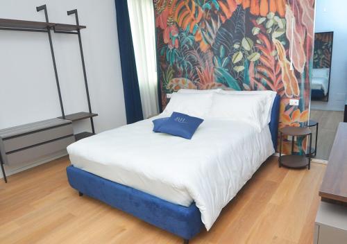 a bed in a room with a painting on the wall at Boutique Hotel Magenta in Magenta