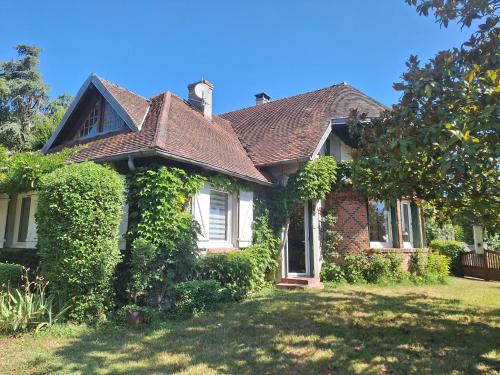 chambre d'hôte في Saint-Rémy-en-Rollat: منزل ينمو اللبلاب على جانبه