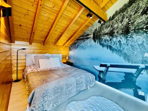 a bed in a log cabin with a swimming pool at La lisière romantique in Granges-Aumontzey