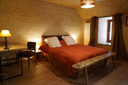 a bedroom with a bed and a desk and a window at Plantes et sabots in Barriac-les-Bosquets