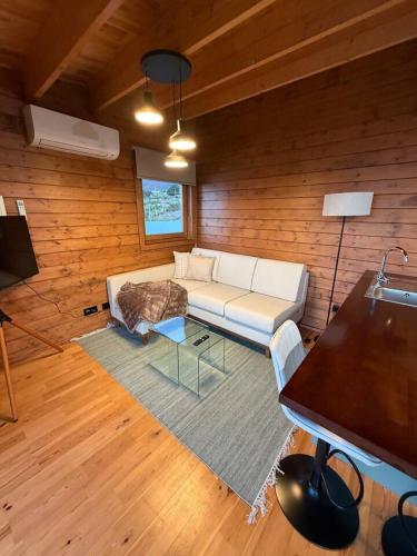 a living room with a white couch and a table at Sunset Eco Shelter 5 in Ponta do Pargo