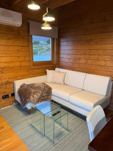 a living room with a couch and a glass table at Sunset Eco Shelter 5 in Ponta do Pargo