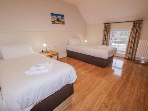 a hotel room with two beds and a window at Foyle Cottage in Strabane