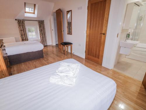 a hotel room with a bed and a bathroom at Foyle Cottage in Strabane