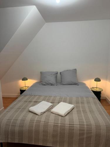 a bedroom with a bed with two towels on it at Logement 11 parking gratuit in Poitiers