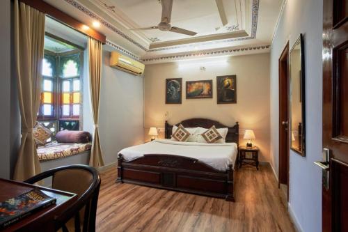 a bedroom with a bed and a table in a room at Elysium Retreat- The Heritage Haveli in Udaipur