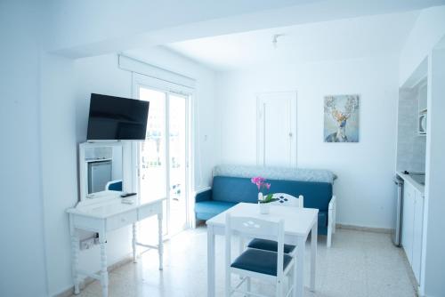 a living room with a blue couch and a table at Flisvos Beach Apartments in Protaras