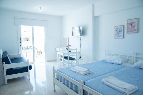 a bedroom with a bed and a table and a chair at Flisvos Beach Apartments in Protaras