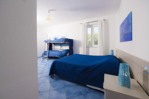 a bedroom with a blue bed and a window at Belvedere in Procida