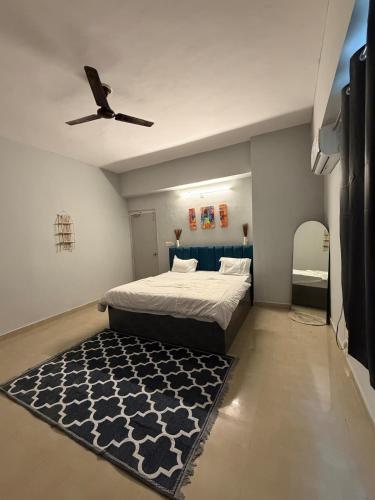 a bedroom with a bed with a ceiling fan and a rug at Elegant 1BHK at Shiva Stays, behind lulu mall in Lucknow