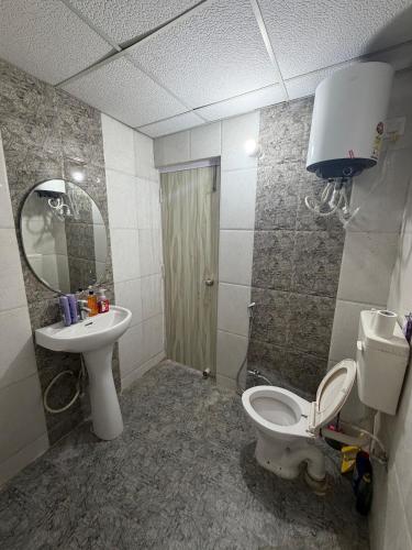 a bathroom with a toilet and a sink and a mirror at Elegant 1BHK at Shiva Stays, behind lulu mall in Lucknow
