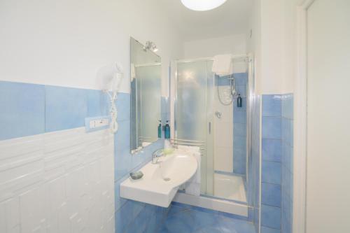 a blue and white bathroom with a sink and a shower at Belvedere in Procida