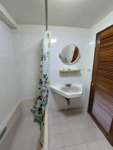 a bathroom with a sink and a tub and a mirror at BaanSathorn21 in Bangkok