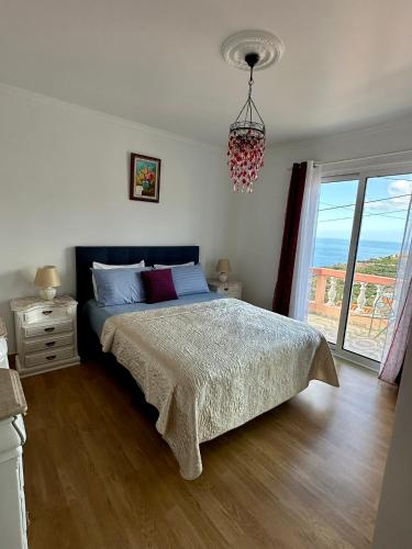 a bedroom with a bed and a large window at Blue Paradise Apartment in Ribeira Brava