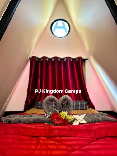 a bedroom with a red bed with a red curtain at พีเจ คิงดอม โฮมสเตย์ in Buriram