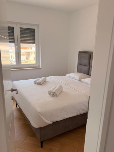 a bedroom with a bed with two towels on it at Apartman Sara in Posušje