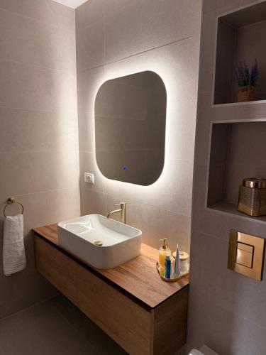a bathroom with a sink and a mirror at Apartman Sara in Posušje