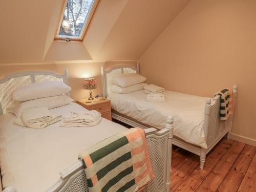 two twin beds in a attic room with a window at Golden Valley View in Stroud