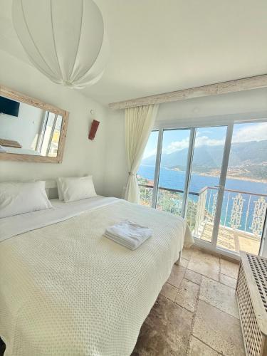 a bedroom with a bed and a large window at Feraye Villas in Kaş