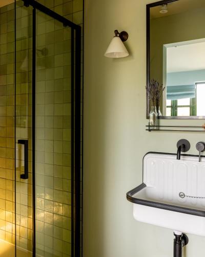 a bathroom with a sink and a shower at The Merry Harriers Pub in Hambledon