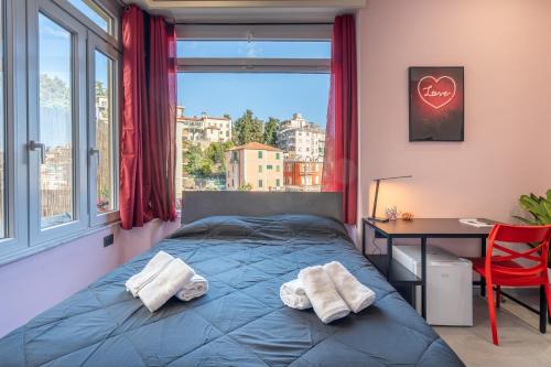 a bedroom with a bed and a desk and a window at Seashell Luxury Rooms Sanremo in Sanremo