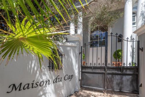 a house with a gate and a palm tree at Maison du Cap in Cape Town