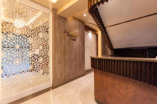 a lobby with a bar with a glass wall at Hotel Olten in Mumbai