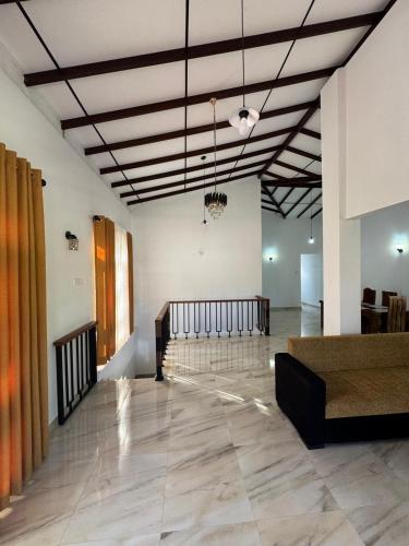 a large room with a lobby with a couch and a unintention at Kahanda Cinnamon Villa in Angulugaha