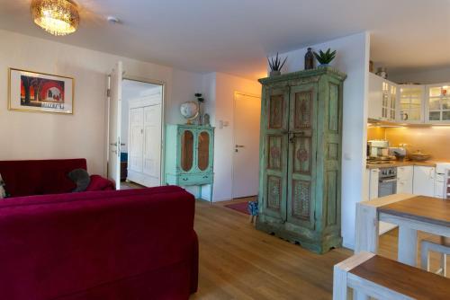 a living room with a red couch and a green cabinet at Karwendelperle -419- in Mittenwald