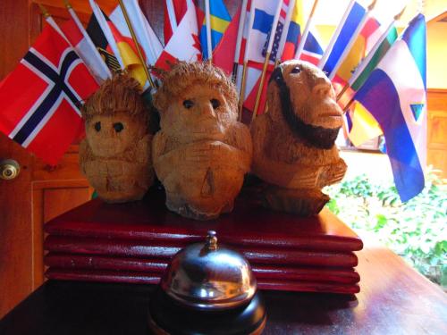 three wooden statues sitting on a table with umbrellas at Hotel El Maltese in Granada