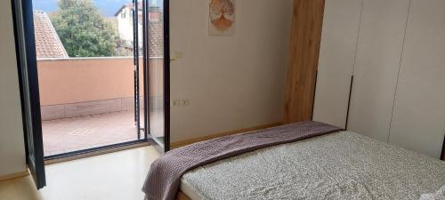 a bedroom with a bed and a large window at apartma Kiana in Šempeter pri Gorici