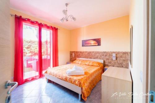 a bedroom with a bed and a window at Le Ville della Contea -Vacation rentals in Mascali