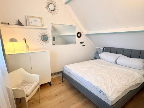 a small bedroom with a bed and a mirror at De Korre 10 in Callantsoog