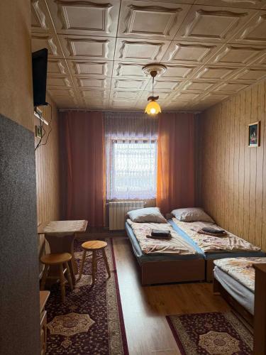 a room with two beds and a table in it at U Janiny in Czarna Góra