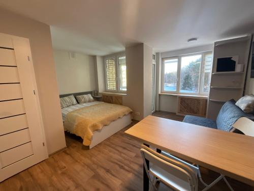 a bedroom with a bed and a table in it at Гнёздышко in Visaginas