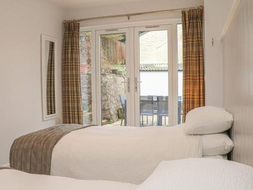 a bedroom with a bed and a window at The Old Workshop in Dulverton