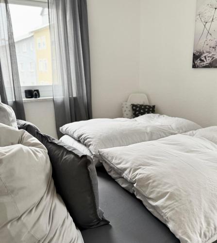 two beds in a room with a window at City Flair by Zirwick Apartment in Weiden