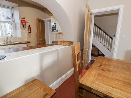 a kitchen with a counter top and a table at Tyddyn Goronwy in Dyffryn