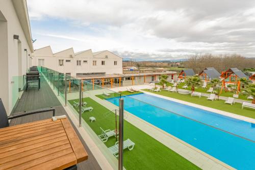 an apartment with a swimming pool on a balcony at Lena Village Hotel and Spa in Mortágua
