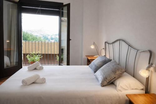 a bedroom with a large white bed with two pillows at Cal Marroso de Montsonís in Montsonis