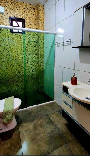 a bathroom with a shower and a toilet and a sink at Escapada do Sonho in Lençóis