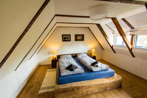 a bedroom with a blue bed in the attic at Ferma de Biodiversitate COBOR in Cobor