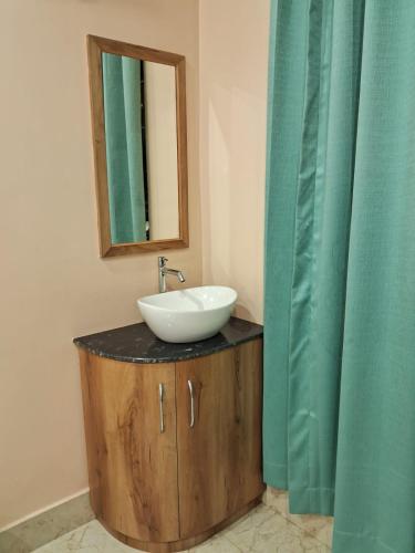 a bathroom with a sink and a mirror at Hotel Maple Lawn in Guwahati