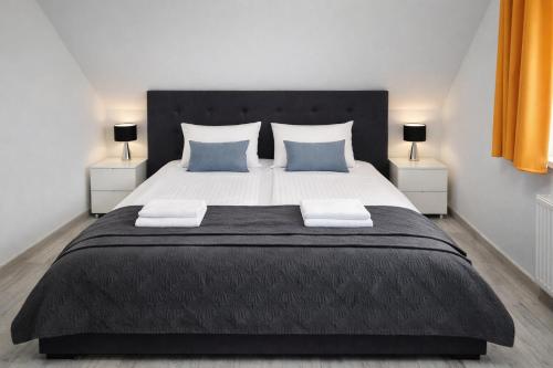 a bedroom with a large bed with blue pillows at Wonderful Dream Apartament z widokiem na Śnieżkę in Karpacz