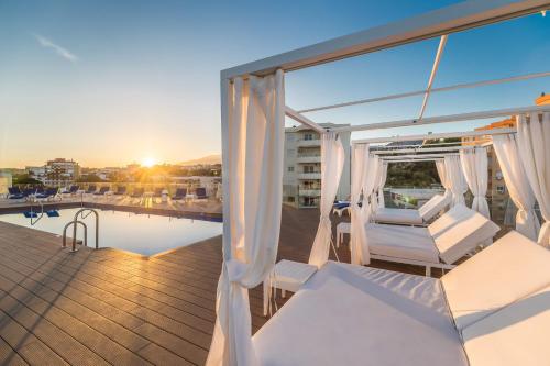 a balcony with white curtains and a pool at Aluasun Lago Rojo - Adults recommended in Torremolinos