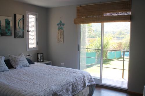 a bedroom with a bed and a large window at Mirabela Casa con vista panorámica a las sierras en Bialet Massé- Hasta 4 personas in Bialet Massé