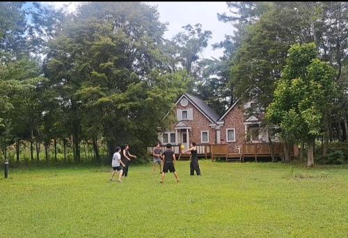 a group of people playing frisbee in front of a house at 山中湖ヴィラクレリエール in Yamanakako
